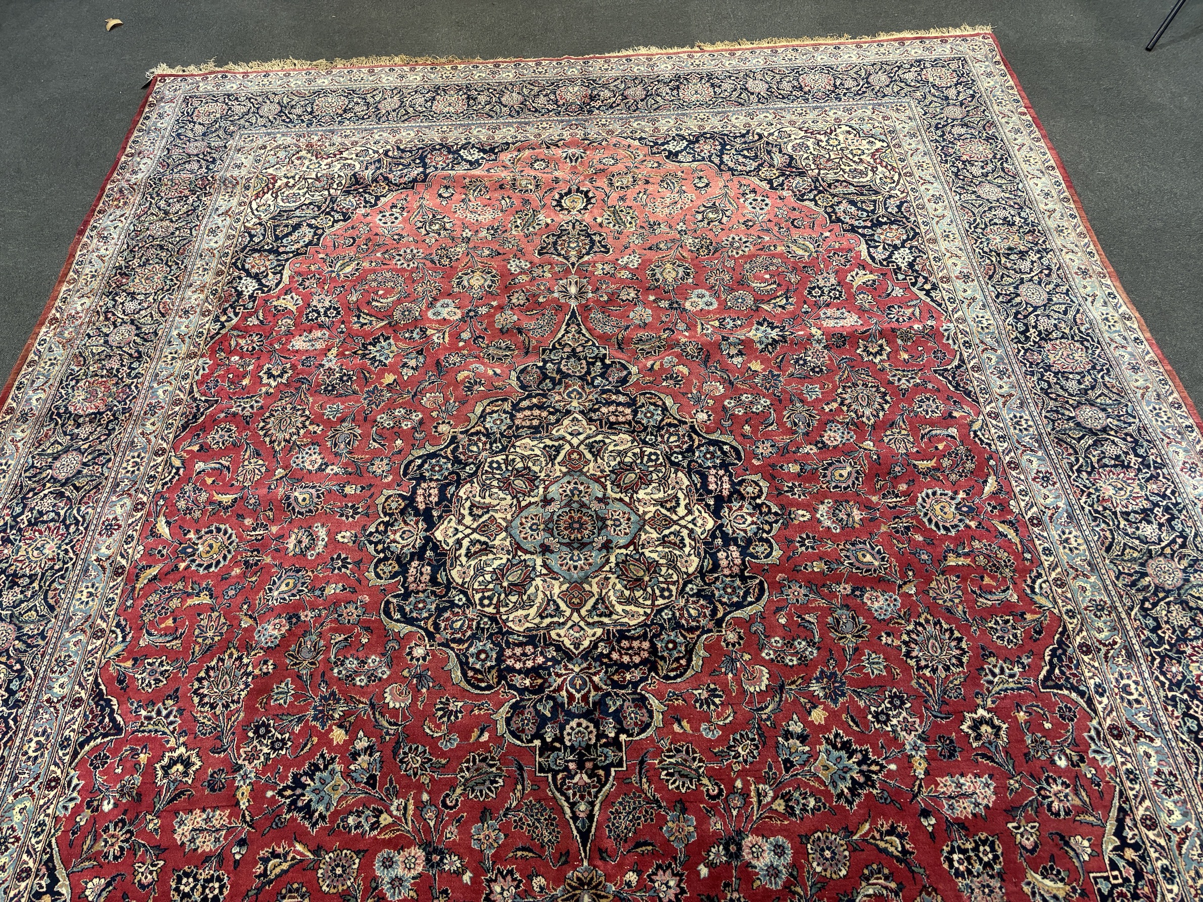 A Persian Kashan carpet with central medallion on a foliate red ground, multi bordered, 430 x 315cm